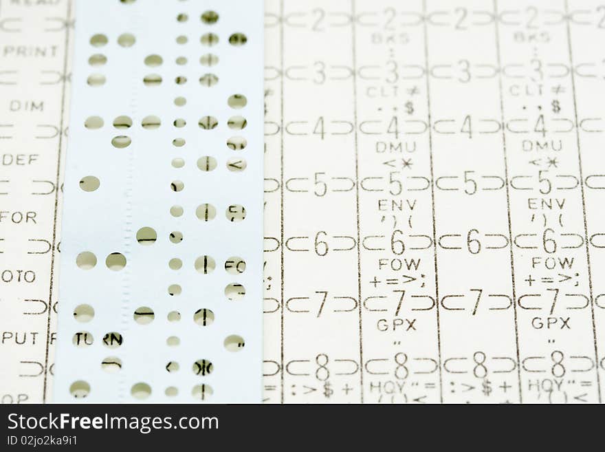 A close up of computing card and punched paper tape used in the 1960 - 70's computing industry. A close up of computing card and punched paper tape used in the 1960 - 70's computing industry