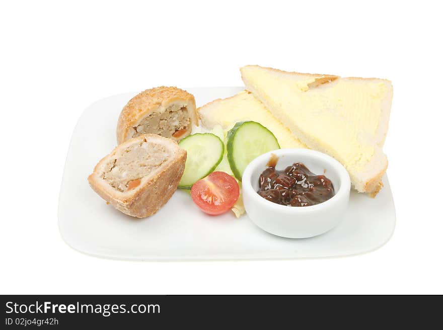 Pork pie with salad garnish,pickle and buttered bread. Pork pie with salad garnish,pickle and buttered bread