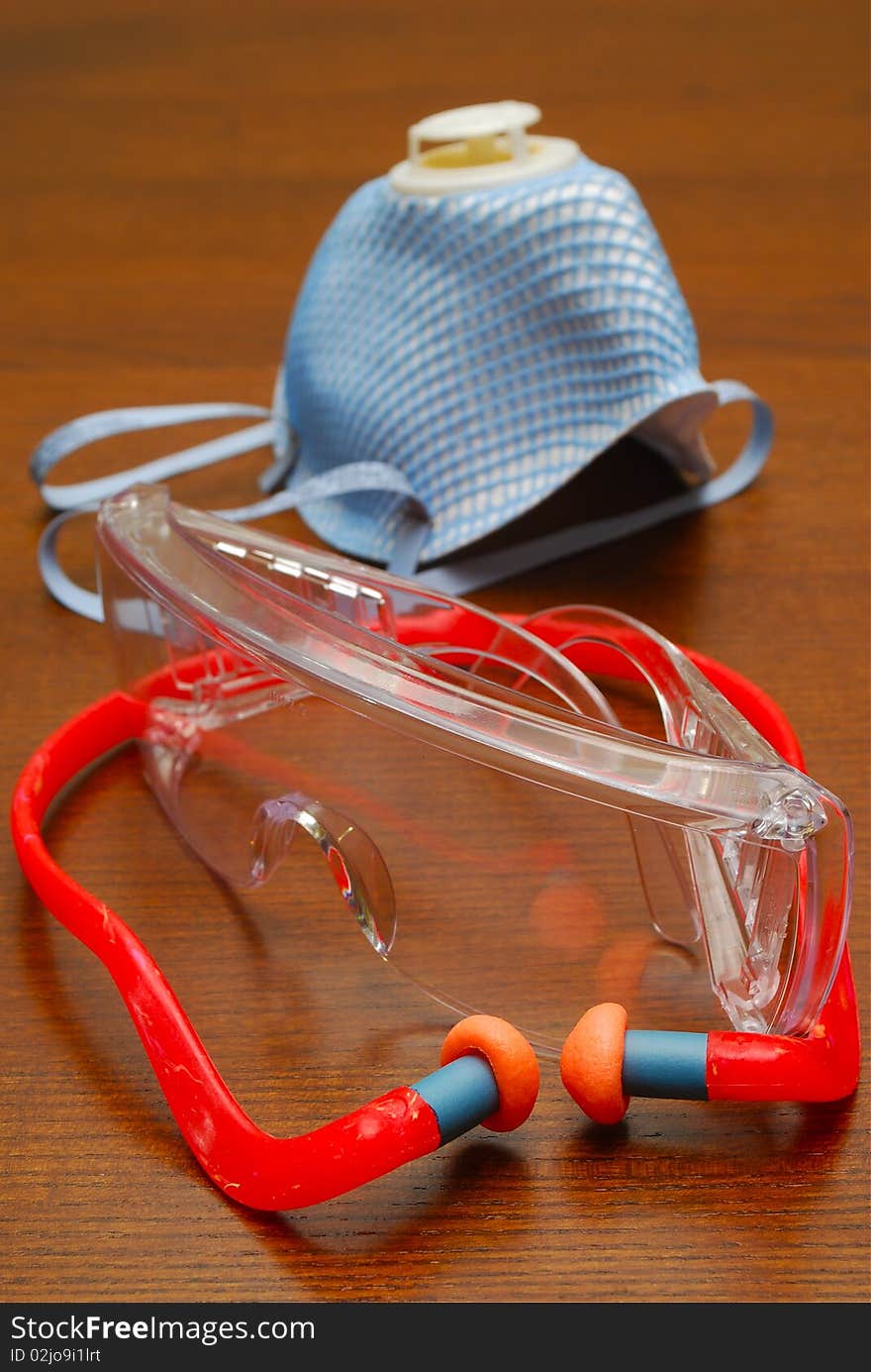 Mask goggles and ear plugs on wooden bench. Mask goggles and ear plugs on wooden bench