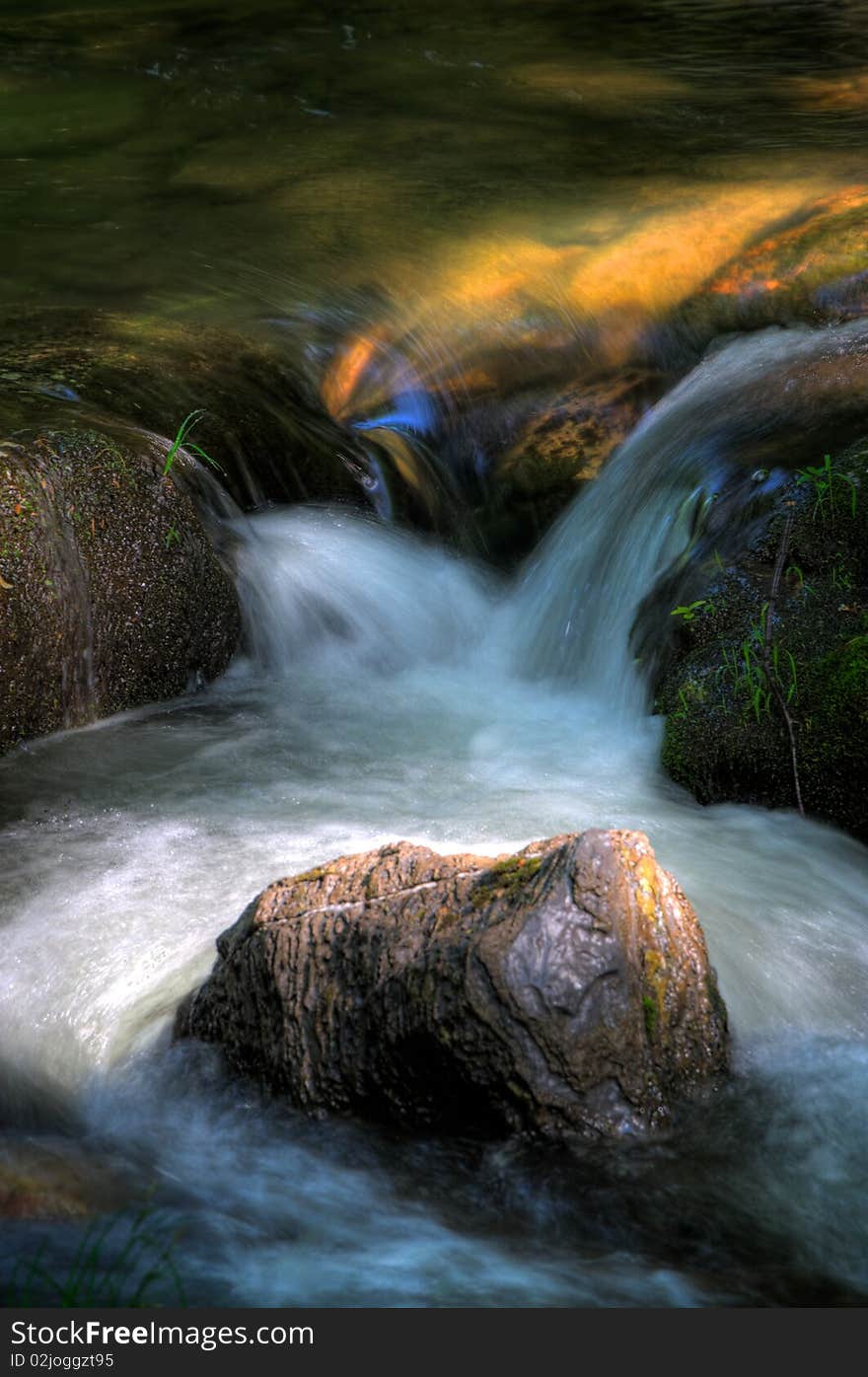 Detail of river rapid with moving water and light reflecting sky and color of rocks. Detail of river rapid with moving water and light reflecting sky and color of rocks