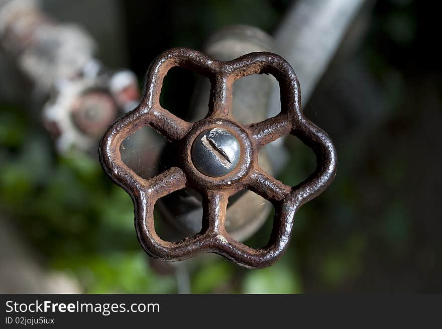 Handle of a water spigot on the side of a 101 year old house. Handle of a water spigot on the side of a 101 year old house.