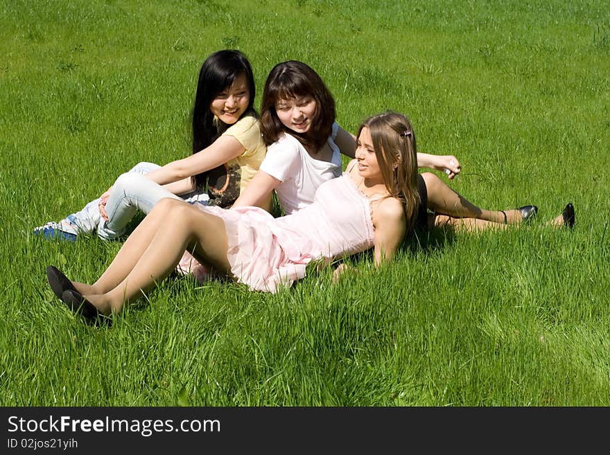 Three girls sitting on grass