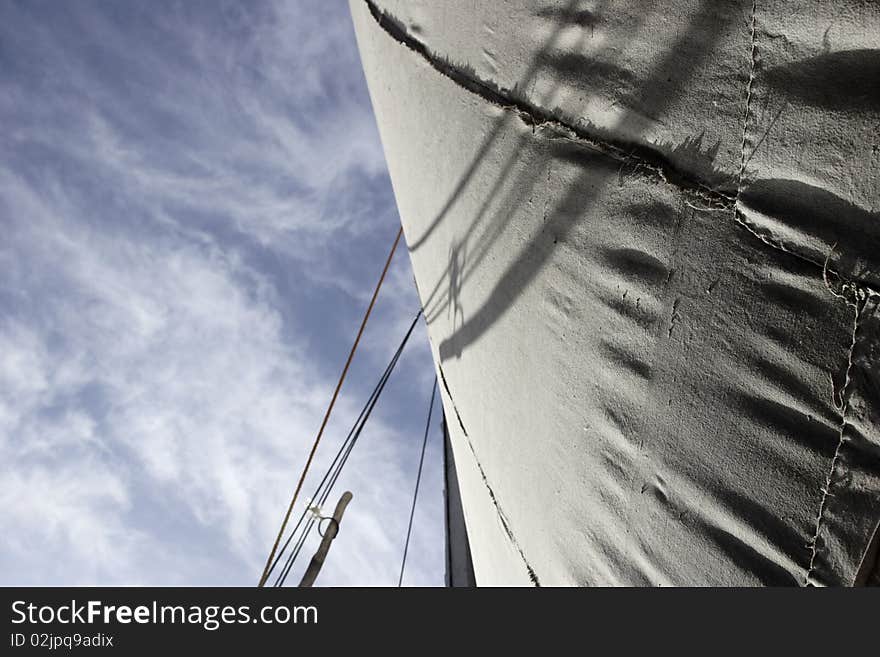 A sail with the sky as a background. The sail shows some texture and shadows. A sail with the sky as a background. The sail shows some texture and shadows.