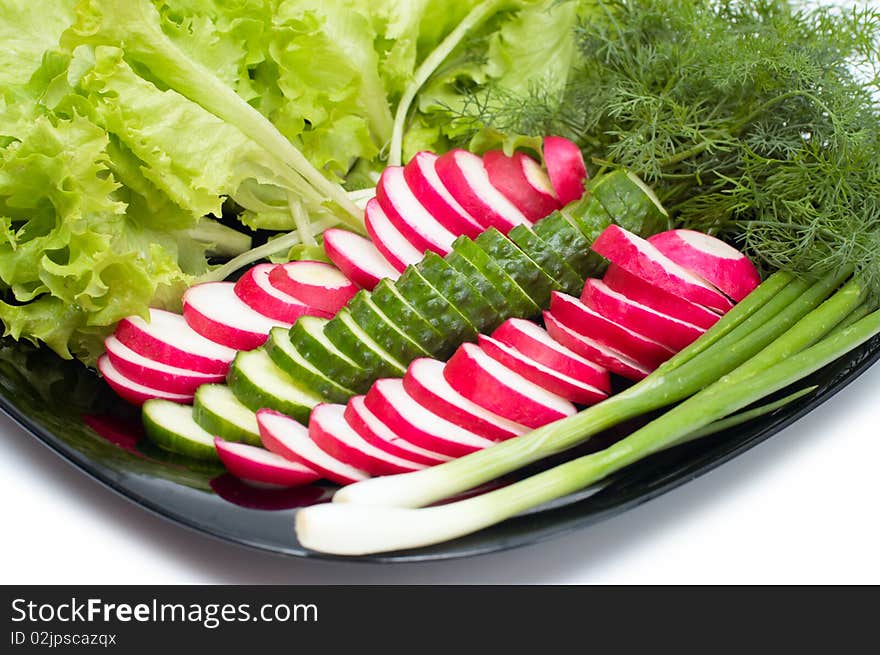 Fresh cucumber, radish and Lettuce on black plate. Fresh cucumber, radish and Lettuce on black plate