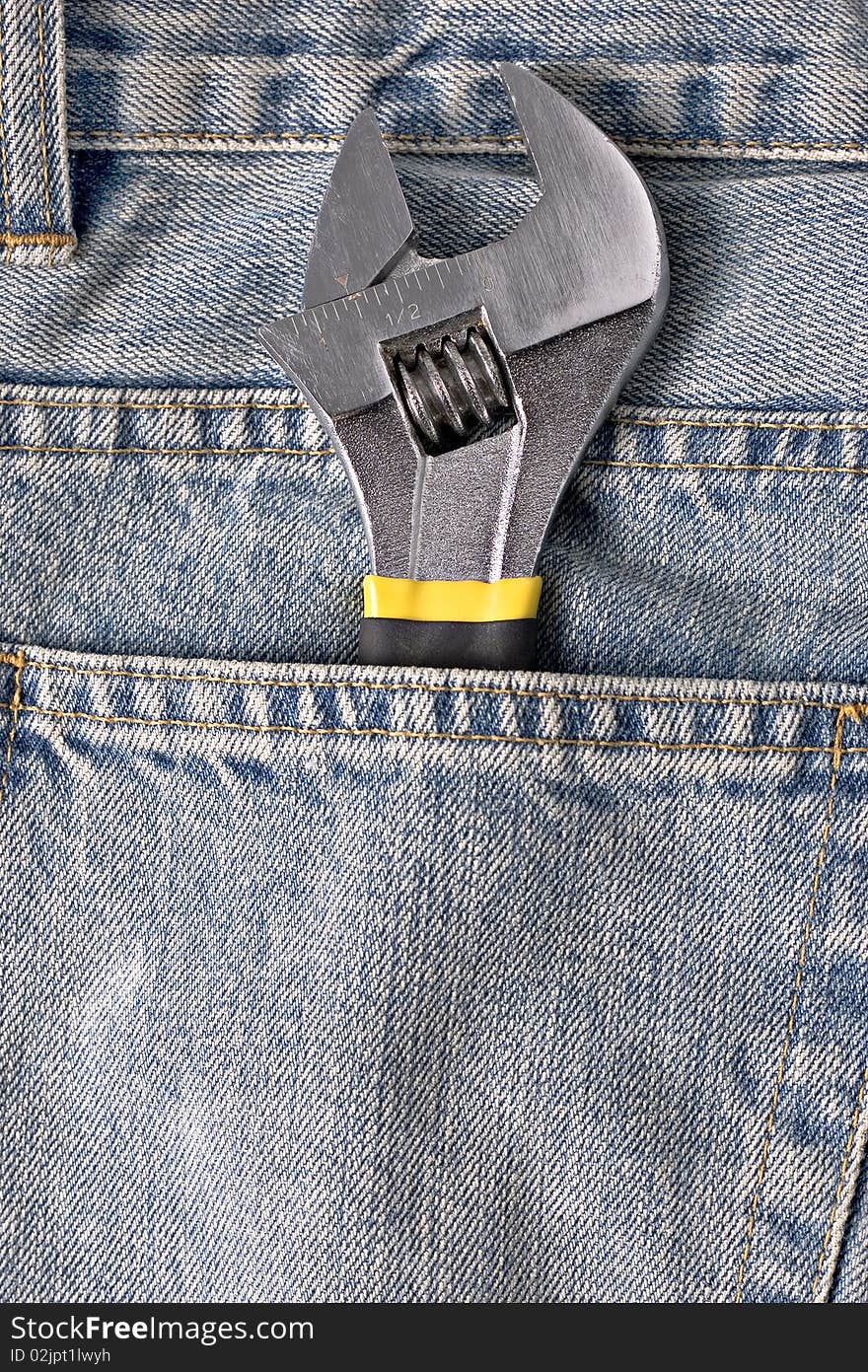 Adjustable spanner in a blue jean pocket. Adjustable spanner in a blue jean pocket