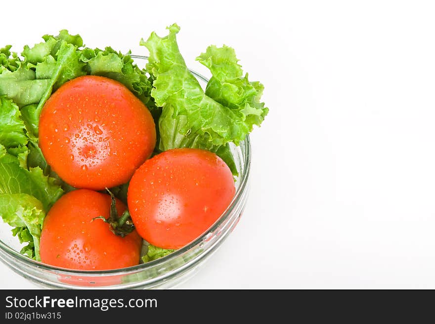 Fresh tomato and lettuce in bowl isolated on white