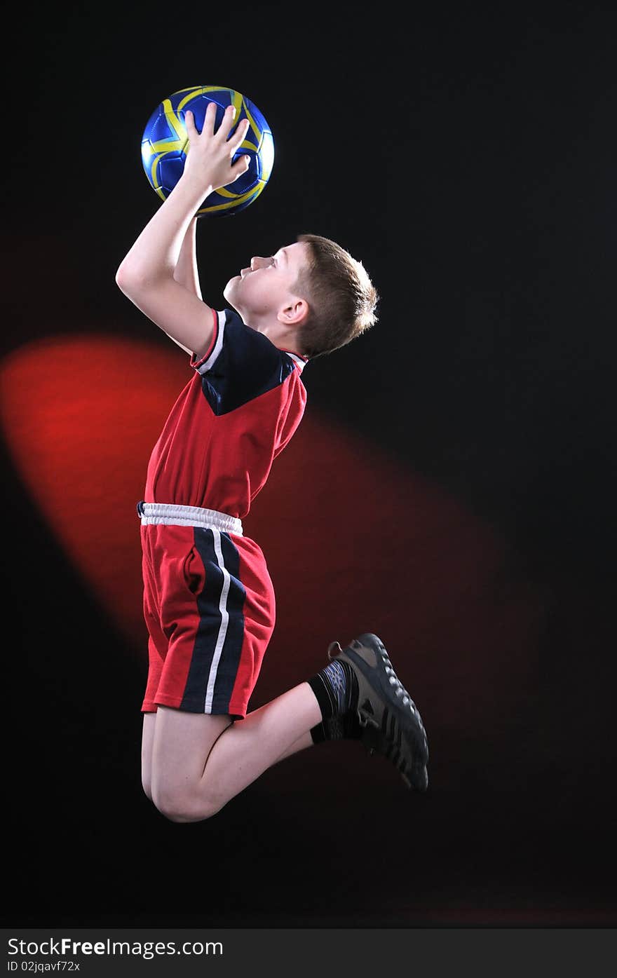 Boy in jump catches a soccer ball