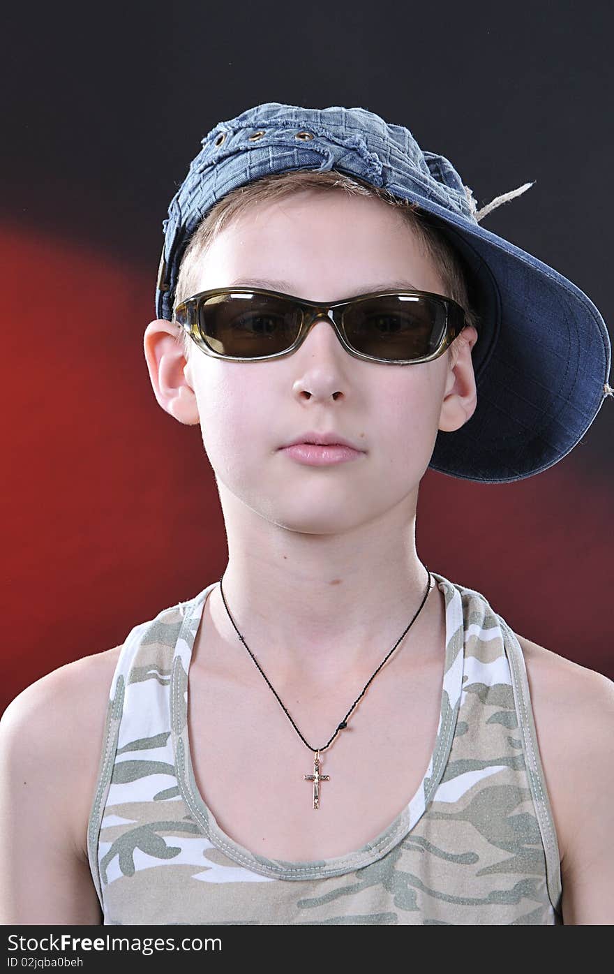 Portrait of is 10-11 years old boy in a jean cap and sun glasses. Portrait of is 10-11 years old boy in a jean cap and sun glasses