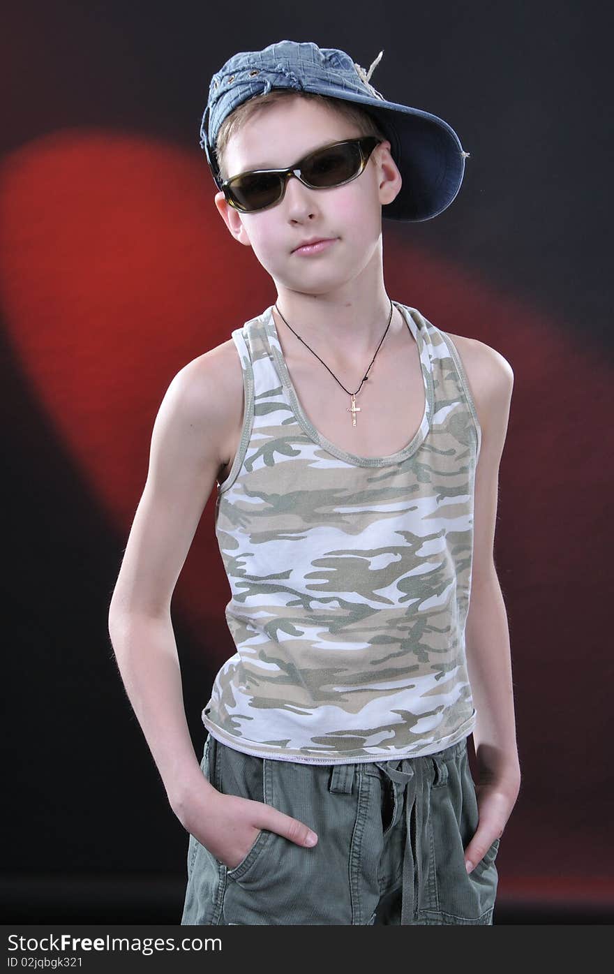 Portrait of is ten years old boy in a jean cap and sun glasses