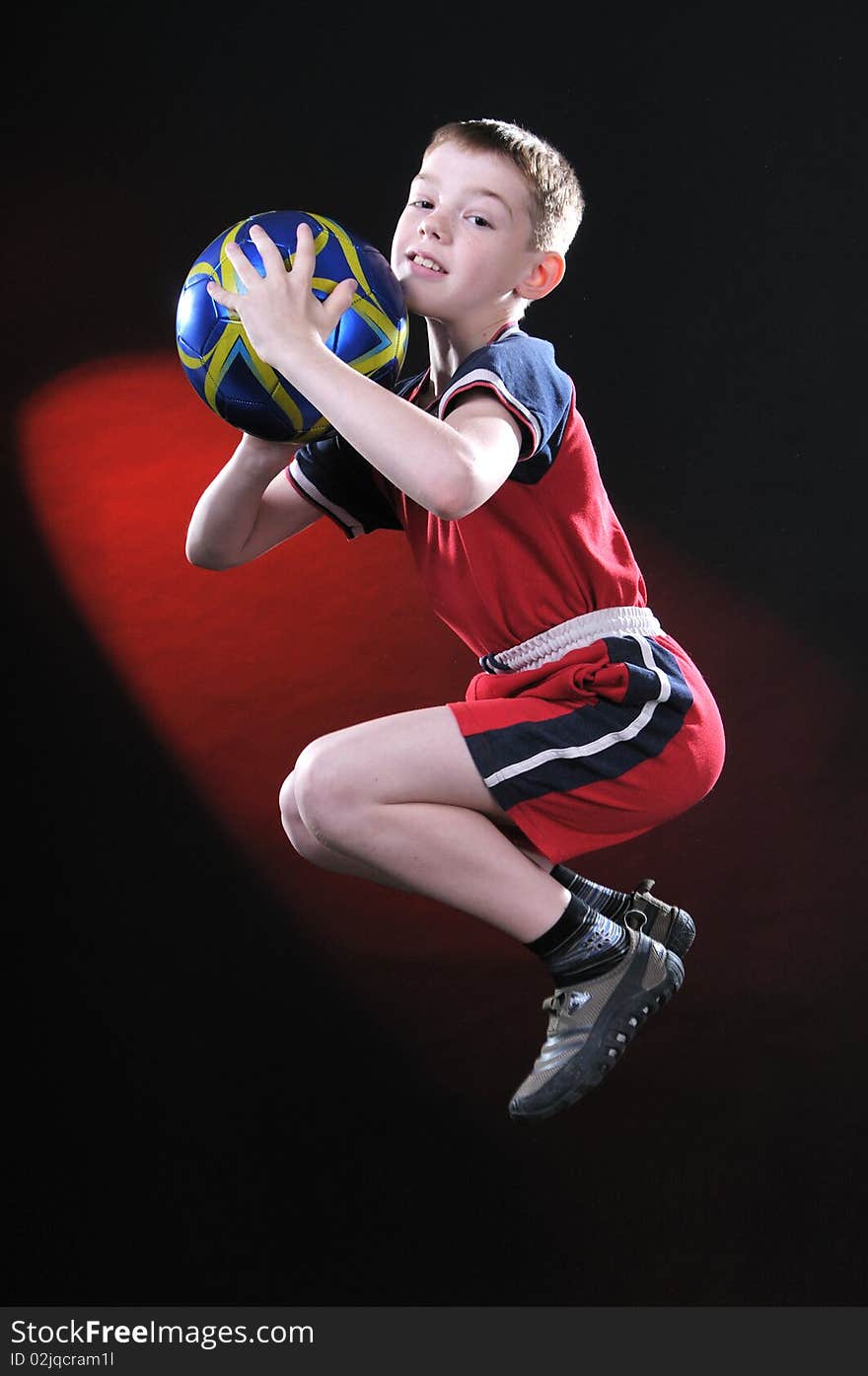 Boy in jump catches a soccer ball