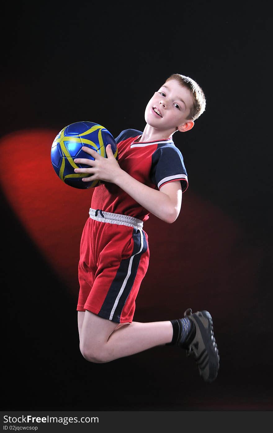 Boy in jump catches a soccer ball