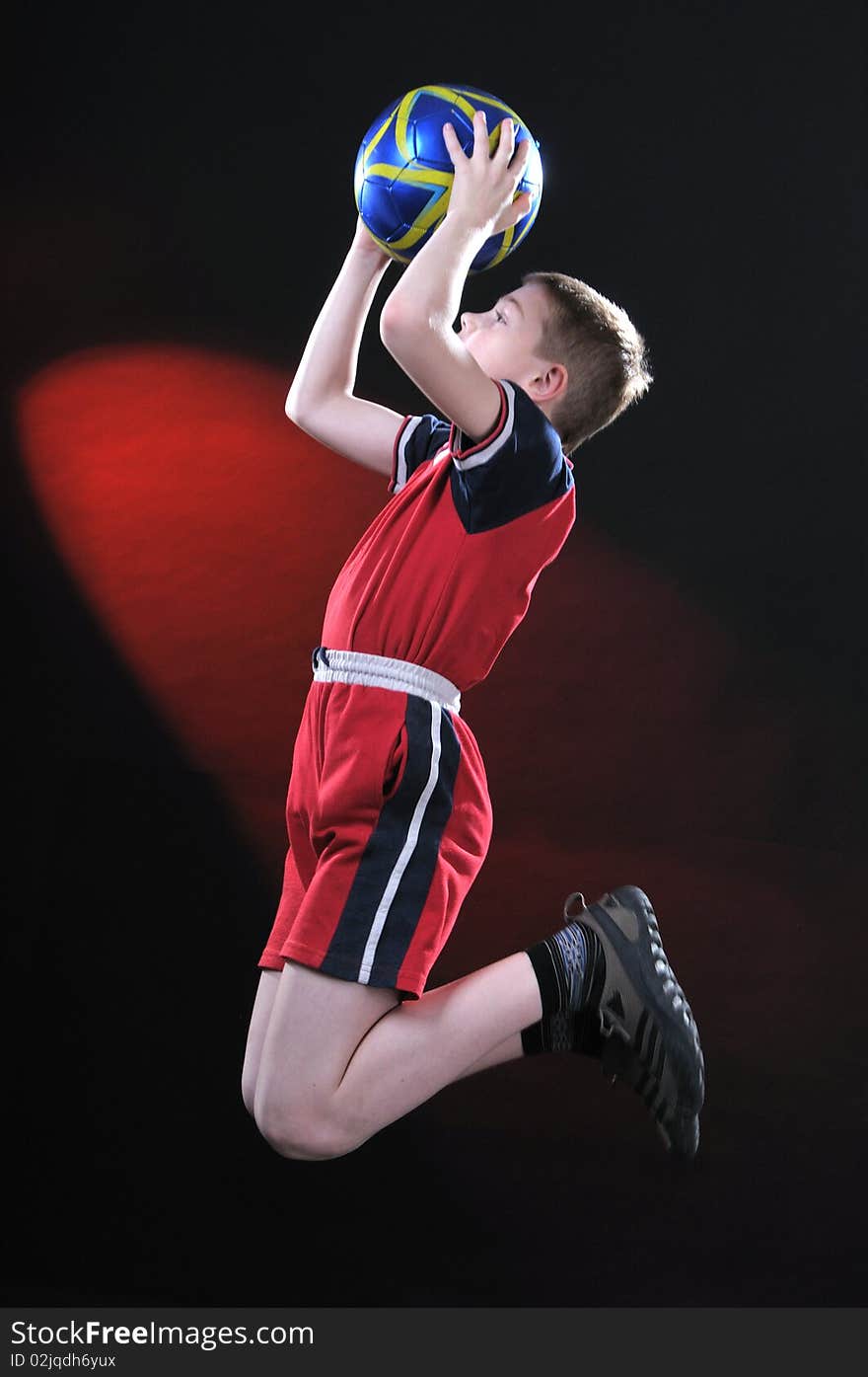 Boy in jump catches a soccer ball