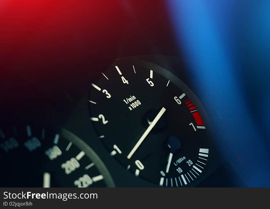 Scales of devices on a car dashboard with colored lights