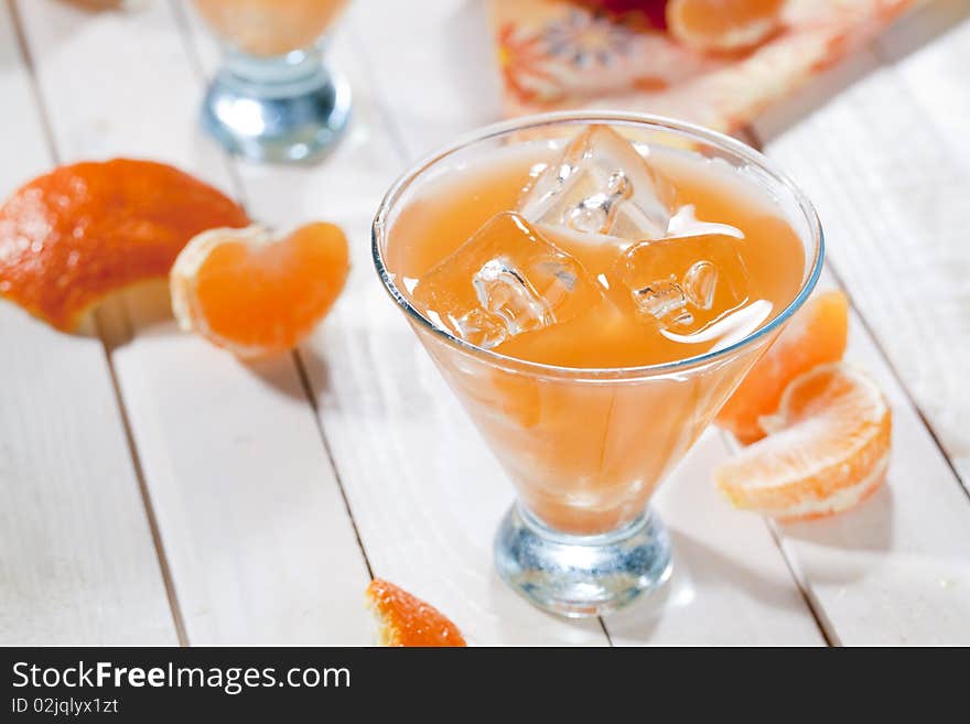 Clas of tangerine cocktail on wooden table top