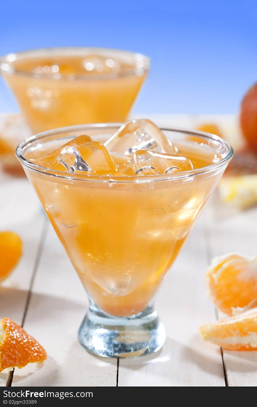 Tangerine cocktail on wooden table top and blue background