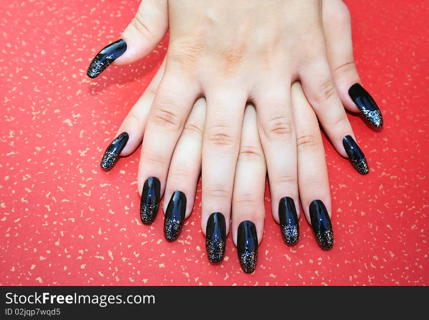 Woman hands with nail art isolated on spotted red background.