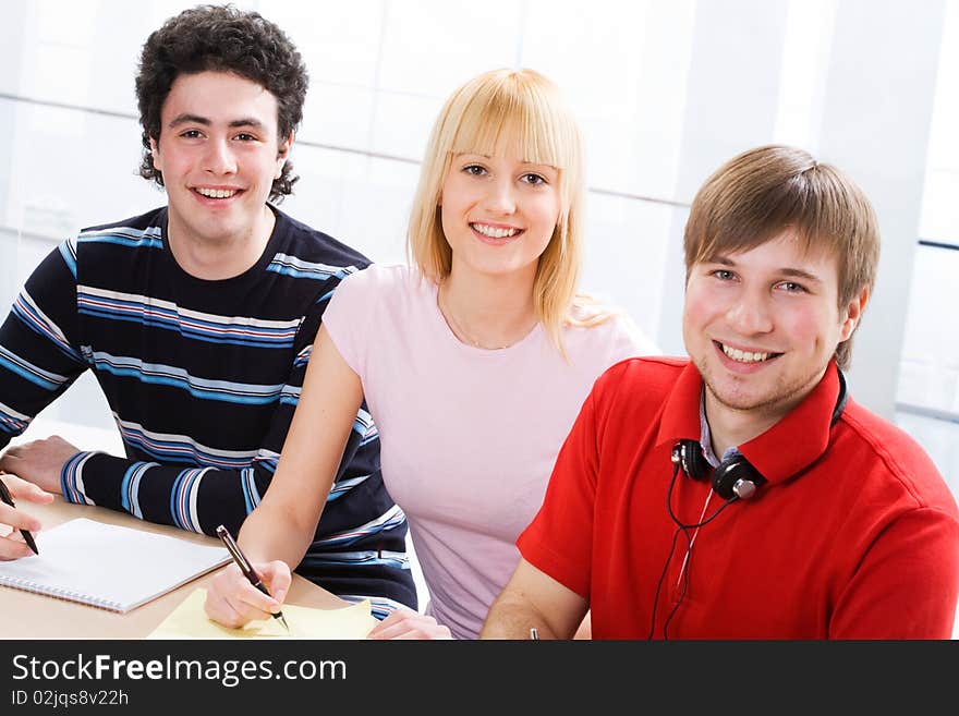 The group of students smiles looking at the camera