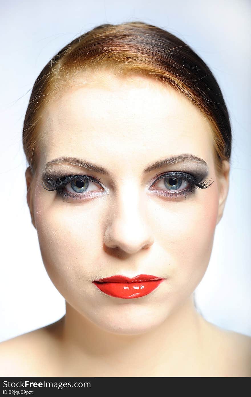 Young beauty female face with red shiny lips