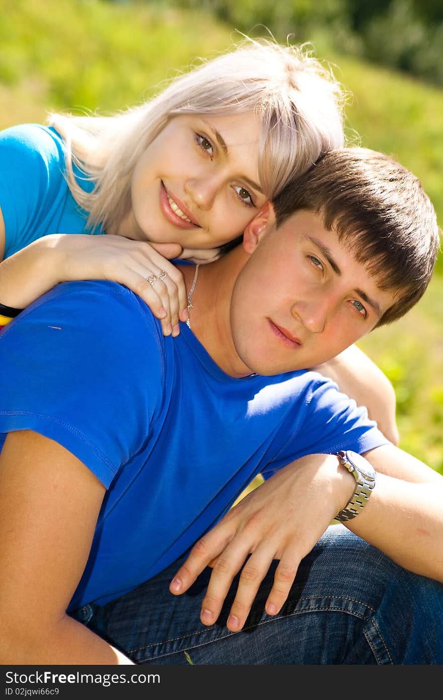 Young couple in the park. Looking At Camera.