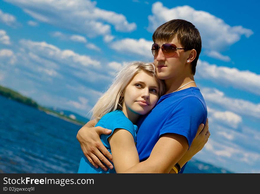 Couple of young beautiful people against the cloudy landscape. Couple of young beautiful people against the cloudy landscape