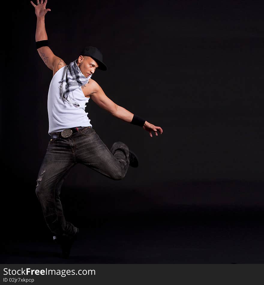 Young stylish asian dancer in front of black background moving to hip jop music. Young stylish asian dancer in front of black background moving to hip jop music.