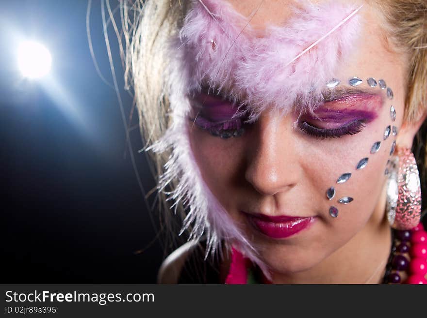 Young stylish teenager with an extreme makeup with feathers and diamonds. Young stylish teenager with an extreme makeup with feathers and diamonds.