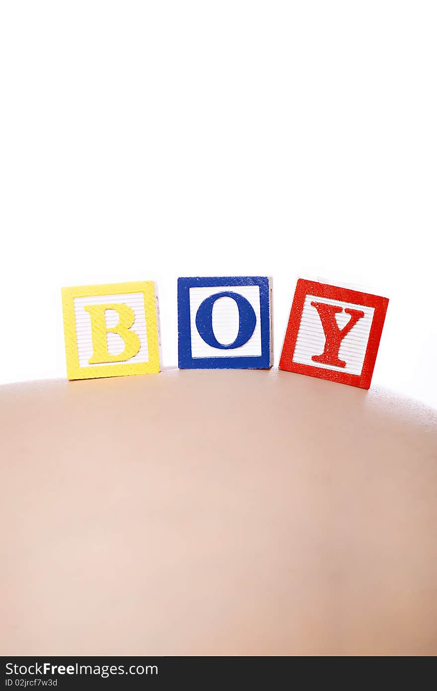 Pregnant belly with wooden playing blocks spelling the word Boy