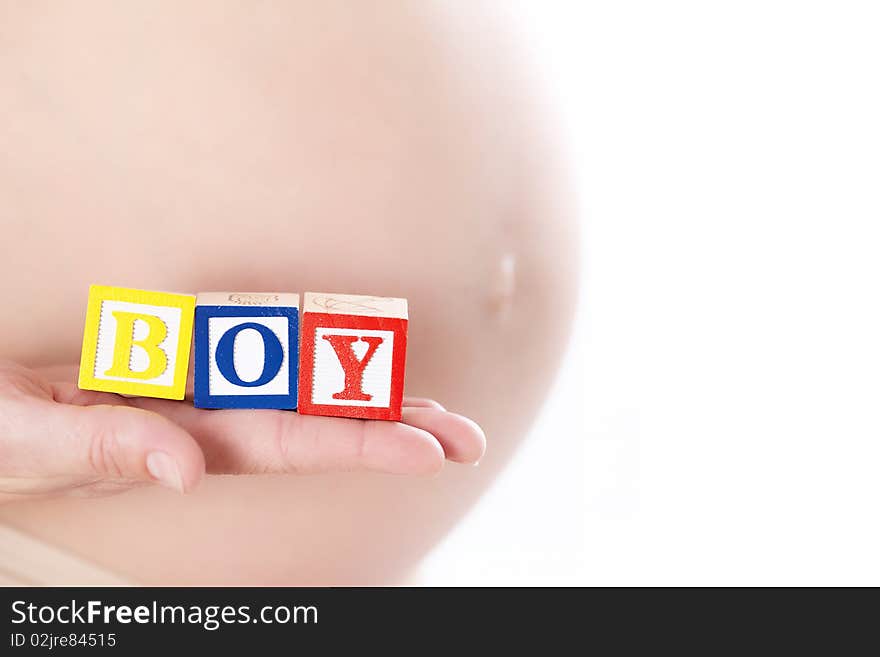 Pregnant belly with wooden playing blocks spelling the word Boy