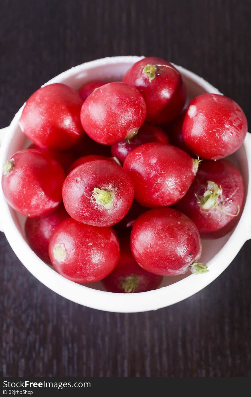 Fresh garden radishes in a white bowl