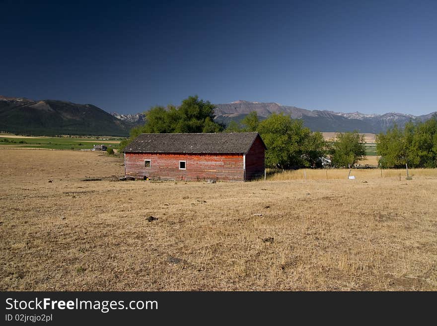 OIld barn in the country side with mountains at the back. OIld barn in the country side with mountains at the back