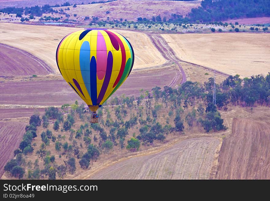 A hot air balloon above fields landscape