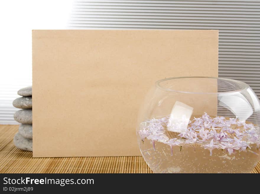 Against the background of rocks and the bowl with water and flowers, a clean sheet of brown paper. Against the background of rocks and the bowl with water and flowers, a clean sheet of brown paper