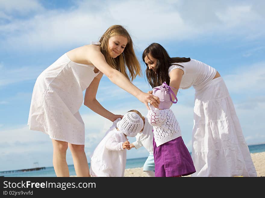 Happy Mothers With Children At The Beach