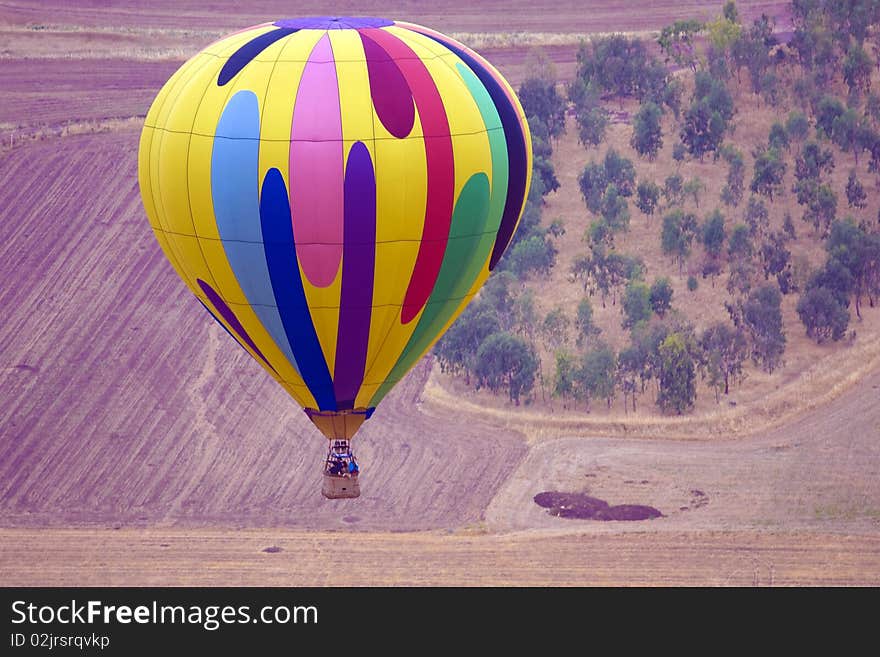 A hot air balloon above fields landscape