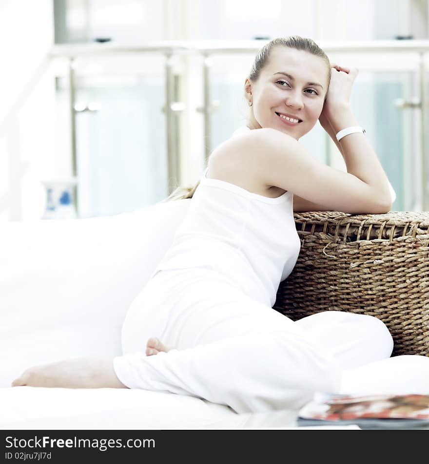 Happy young woman in white at home