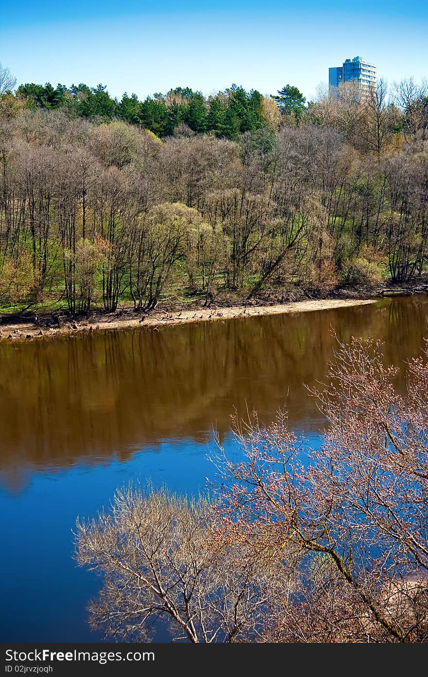 Lithuania landscape - river and a forest turning green, in spring