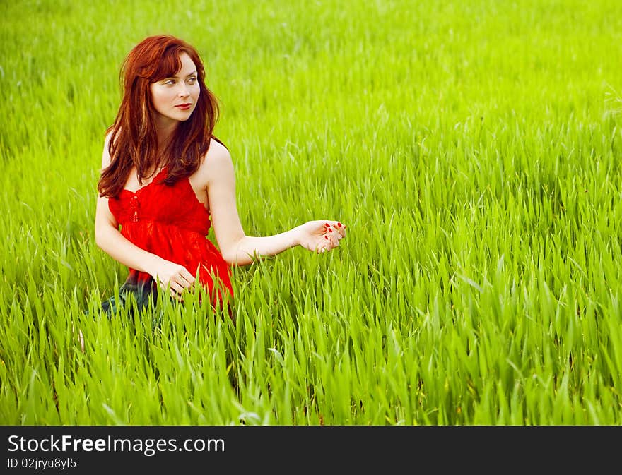 Woman in red enjoying nature in a green field. Woman in red enjoying nature in a green field