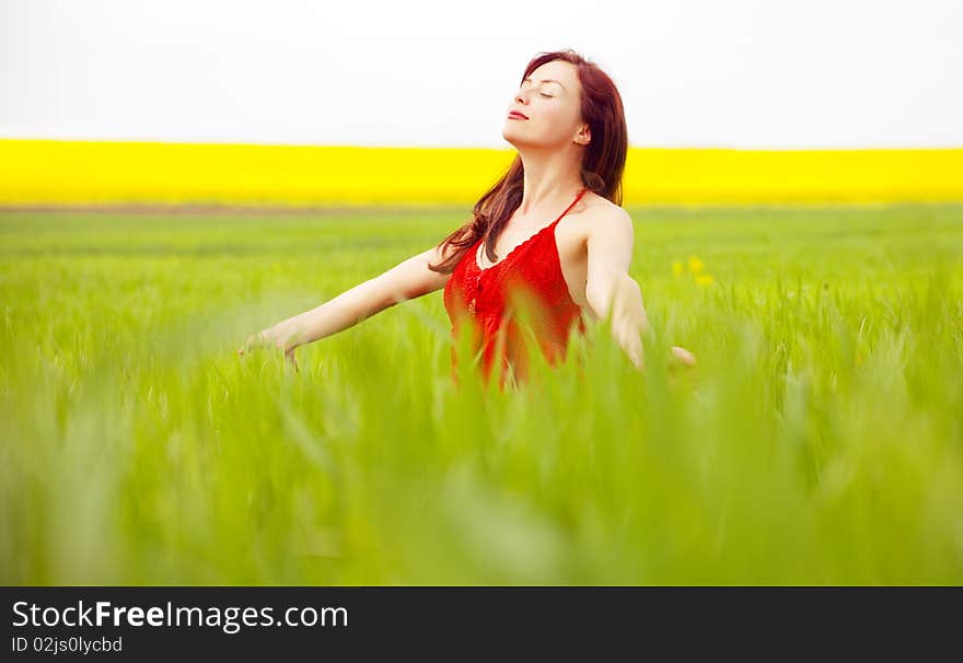 Woman in red enjoying nature in a green field. Woman in red enjoying nature in a green field