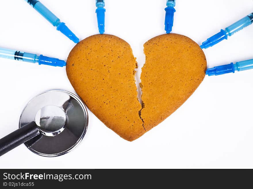 Healing a broken heart with blue syringe and a stethoscope on white background