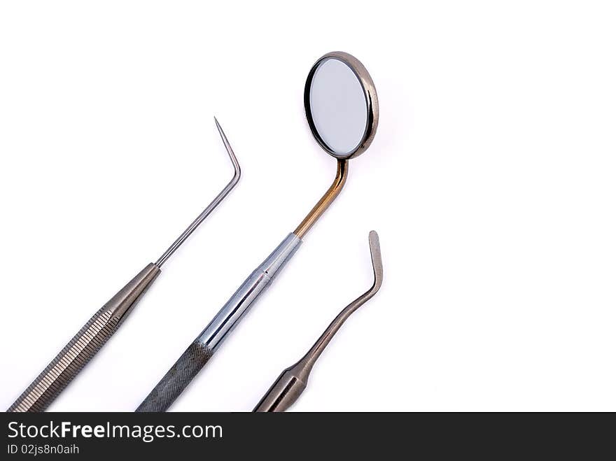 Dental tools: oral mirror, tweezers and spatula on white background