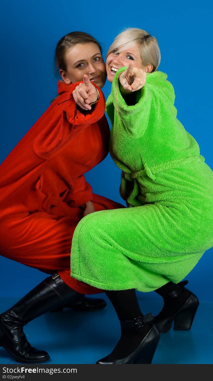 Two beautiful smiling friends girls in the bathrobes. Two beautiful smiling friends girls in the bathrobes