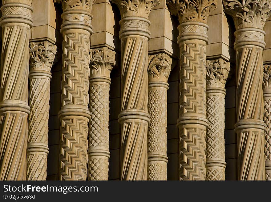 Row of columns of Natural History Museum in London. Sandy color of symmetry columns with details of architecture and fretwork. Row of columns of Natural History Museum in London. Sandy color of symmetry columns with details of architecture and fretwork.