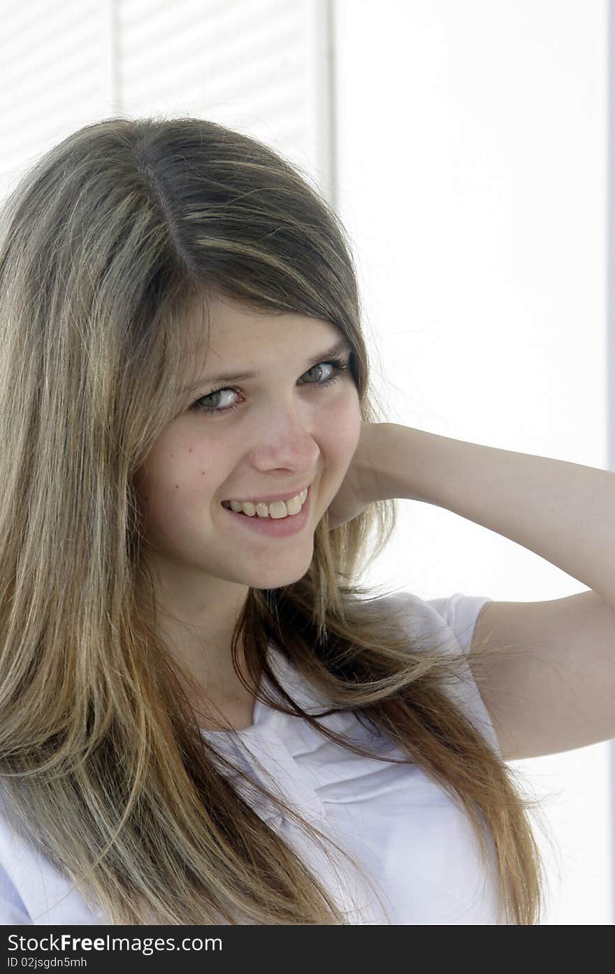 Smiling young lady touching hair. Smiling young lady touching hair