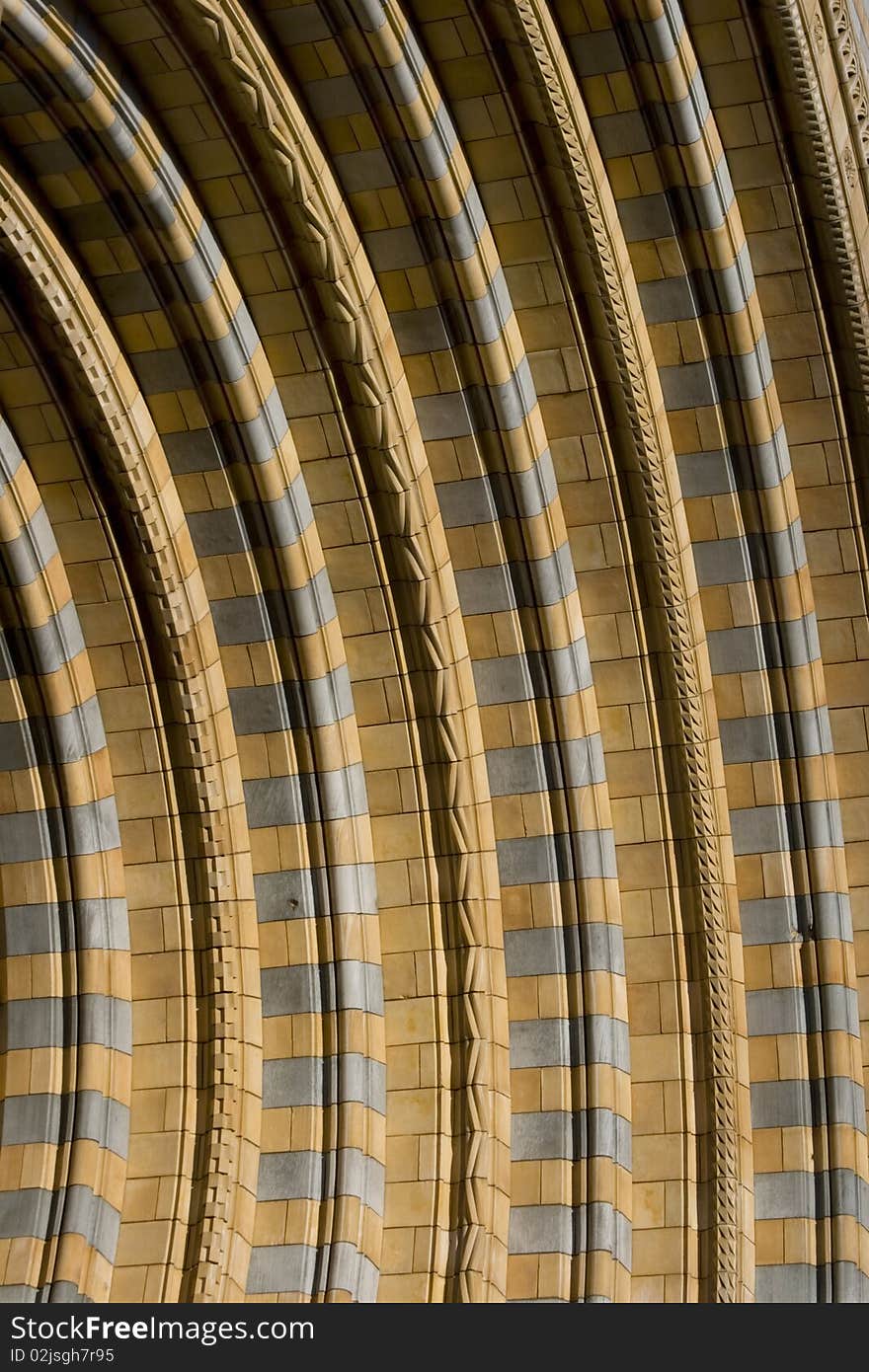 Row of tile of Natural History Museum in London. Sandy color of symmetry lines with rough details of architecture. Row of tile of Natural History Museum in London. Sandy color of symmetry lines with rough details of architecture.