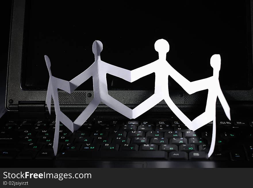 A chain of paper fellows on laptop