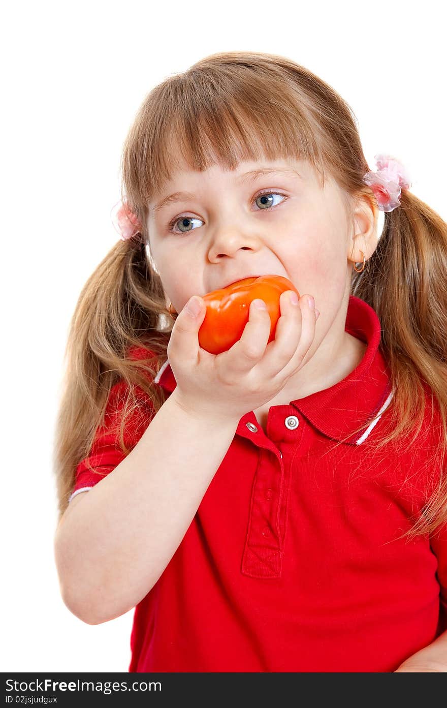 The girl eats a tomato.