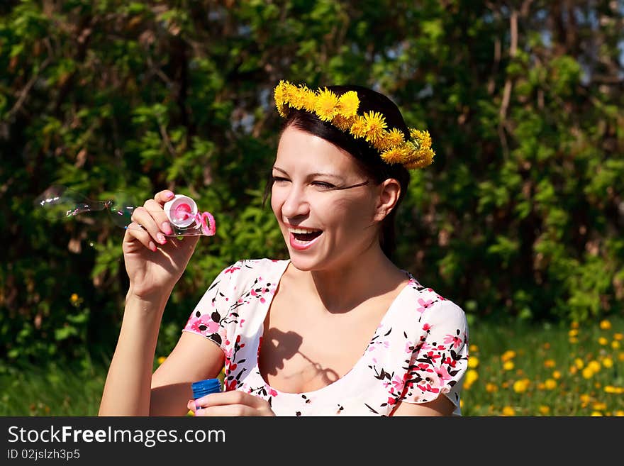 Young beautiful girl blowing bubbles in the nature. Young beautiful girl blowing bubbles in the nature