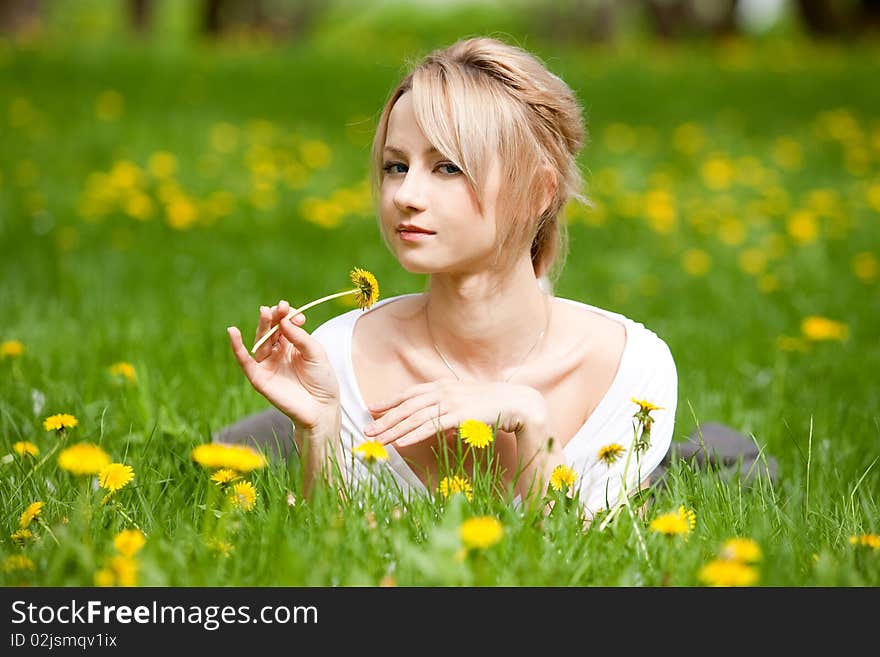 Blonde girl in dandelions, outdoors