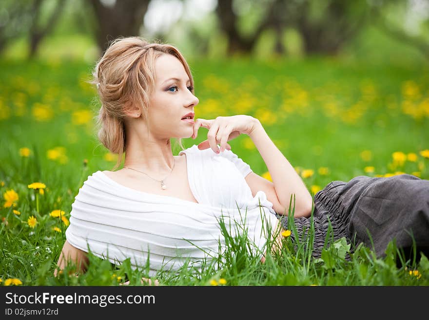 Blond girl relaxing in dandelions