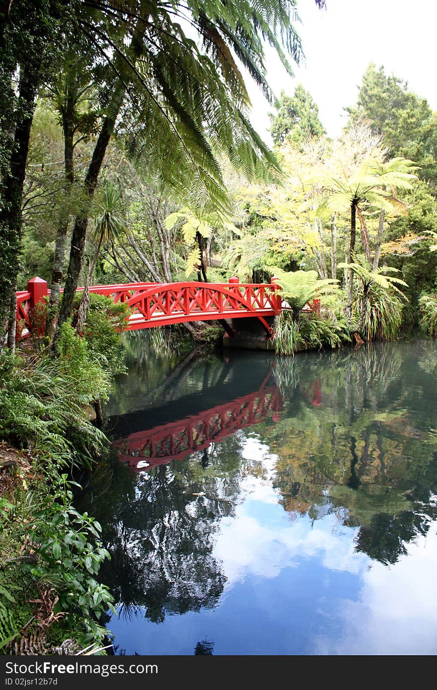 Red bridge over still pond